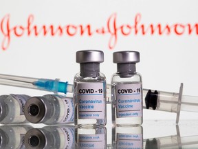 Vials labelled "COVID-19 Coronavirus Vaccine" and syringe are seen in front of displayed Johnson & Johnson logo in this illustration taken, February 9, 2021.