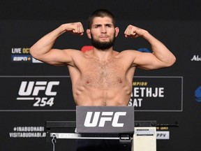 In this handout image provided by UFC, Khabib Nurmagomedov of Russia poses on the scale during the UFC 254 weigh-in on Oct. 23, 2020 on UFC Fight Island, Abu Dhabi, United Arab Emirates.