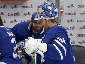 Maple Leafs goalies Jack Campbell (on the bench) and Frederik Andersen chat during a break in action on Jan. 18.