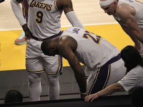 LeBron James, centre, of the Los Angeles Lakers reacts to an apparent injury during the second period of a game against the Atlanta Hawks at Staples Center on March 20, 2021 in Los Angeles, Calif.