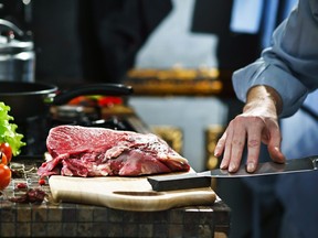 Man sharpens kitchen knife for cutting meat on the whetstone