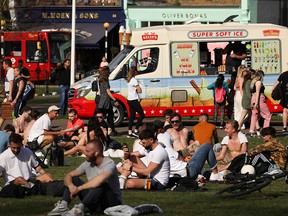 People enjoy the weather at Clapham Common, in London, March 30, 2021.