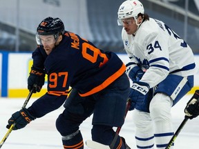 Edmonton Oilers’ Connor McDavid (97) battles Toronto Maple Leafs’ Auston Matthews (34) during first period NHL action at Rogers Place in Edmonton, on Jan. 28, 2021.