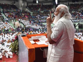 In this handout photograph taken on February 14, 2021 and released by the Indian Press Information Bureau (PIB), India's Prime Minister Narendra Modi gestures as he addresses a gathering in Chennai.