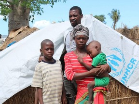 A woman, called Elsa by U.K.-based aid group Save the Children, stands with her family in a displacement camp in the northern Mozambique province of Cabo Delgado, in this handout photo taken Jan. 26, 2021.
