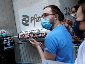 Demonstrators clap outside Pfizer's headquarters building, at a "Free the Vaccine" protest, demanding just global distribution of COVID-19 vaccines during the coronavirus pandemic in New York City, March 11, 2021.