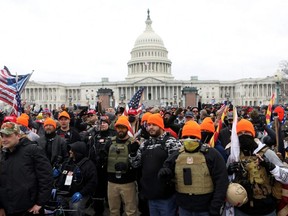 Members of the far-right group Proud Boys make 'OK' hand gestures indicating "white power" as supporters of U.S. President Donald Trump gather in front of the U.S. Capitol Building to protest against the certification of the 2020 U.S. presidential election results by the U.S. Congress, in Washington, D.C., Jan. 6, 2021.