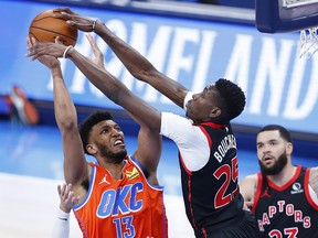 Oklahoma City Thunder center-forward Tony Bradley (13) is defended by Toronto Raptors forward Chris Boucher (25) at Chesapeake Energy Arena.