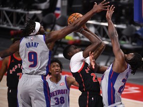Detroit Pistons players swarm Raptors centre Chris Boucher.