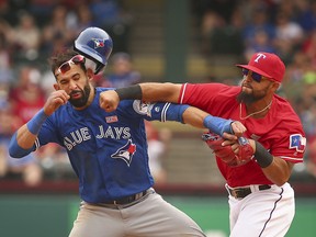 In this May 15, 2016, file photo, Toronto Blue Jays' Jose Bautista, left, is hit by Texas Rangers second baseman Rougned Odor, right, at Globe Life Park in Arlington, Texas.