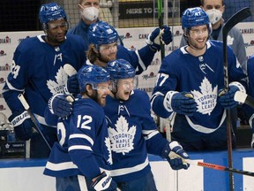 Toronto Maple Leafs centre Alex Galchenyuk (12) joins in the celebration of a goal by linemate Zach Hyman (11) against the Calgary Flames at Scotiabank Arena on March 20, 2021.