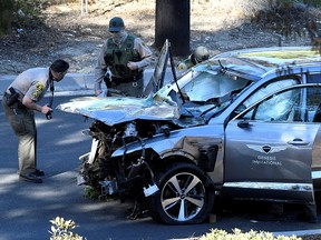 Los Angeles County Sheriff's Deputies inspect the vehicle of golfer Tiger Woods after it was involved in a single-vehicle accident in Los Angeles February 23, 2021.