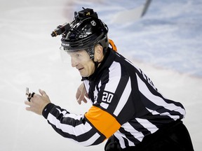 Referee Tim Peel wears a helmet camera during action between the Calgary Flames and Vancouver Canucks in Calgary on Wednesday, Oct. 8, 2014.