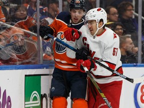 Edmonton Oilers' Ryan Nugent-Hopkins, left, battles Carolina Hurricanes' Trevor van Riemsdyk during the first period of a NHL hockey game at Rogers Place in Edmonton, on Tuesday, Dec. 10, 2019.