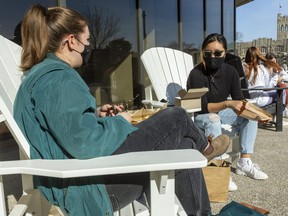 Students enjoy a snack outside the University Community Centre at Western University's concrete beach on Tuesday, March 9, 2021 in London, Ont.