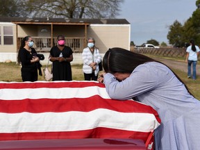 Lila Blanks reacts next to the casket of her husband, Gregory Blanks, 50, who died from complications from the coronavirus, ahead of his funeral in San Felipe, Texas, U.S., January 26, 2021.