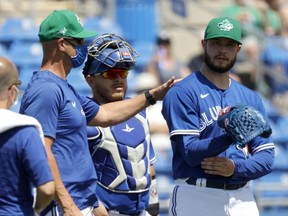 Blue Jays piching coach tends to pitcher Thomas Hatch during a spring-training game. USA TODAY SPORTS