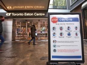 In this file photo, people arrive at the entrance to the Toronto Eaton Centre in downtown Toronto, Ontario on November 23, 2020, the first day of a new lockdown in the city.