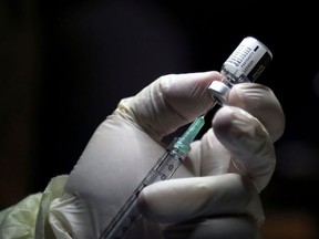 A health-care worker prepares to administer a Pfizer/BioNTEch coronavirus disease (COVID-19) vaccine at The Michener Institute, in Toronto, on Dec. 14, 2020.