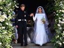 In this file photo taken on May 19, 2018 Britain's Prince Harry, Duke of Sussex and his wife Meghan, Duchess of Sussex walk down the west steps of St George's Chapel, Windsor Castle, in Windsor, after their wedding ceremony.  