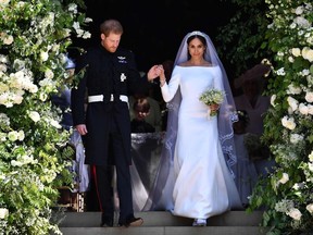 In this file photo taken on May 19, 2018 Britain's Prince Harry, Duke of Sussex and his wife Meghan, Duchess of Sussex walk down the west steps of St George's Chapel, Windsor Castle, in Windsor, after their wedding ceremony.