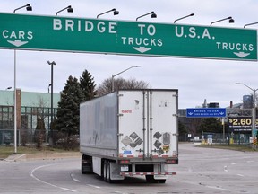 Transport trucks approach the Canada/USA border crossing in Windsor, Ont. on March 21, 2020.