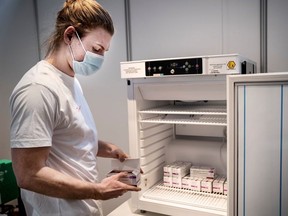 Staff member handles AstraZeneca COVID-19 vaccines in storage at Region Hovedstaden's Vaccine Center, Copenhagen, Denmark February 11, 2021.