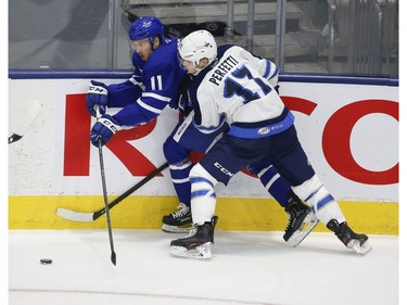 Manitoba Moose Cole Perfetti C (17) takes Toronto Marlies Kalle Kossila C (11) into the boards during the third period in Toronto on Monday March 1, 2021. Jack Boland/Toronto Sun/Postmedia Network