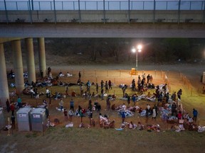 Asylum seeking migrant families and unaccompanied minors from Central America take refuge in a makeshift U.S. Customs and Border Protection processing centre under the Anzalduas International Bridge after crossing the Rio Grande river into the United States from Mexico in Granjeno, Texas, Friday, March 12, 2021.