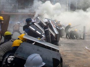 Protesters cover with makeshift shields during an anti-coup protest in Yangon, Myanmar, March 3, 2021.