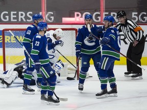Vancouver Canucks forward Jake Virtanen celebrates his game-opening goal with Bo Horvat, Alexander Edler and Tanner Pearson last night at Rogers Arena.