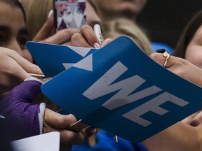 Fans get their sings autographed before the We Day event in Toronto, on Thursday, September 20, 2018.