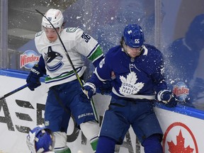 Toronto Maple Leafs defenceman Ben Hutton collides with Vancouver Canucks forward Nils Hoglander on Thursday night.