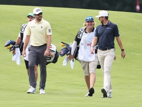 Mackenzie Hughes and Corey Conners of Canada walk up the 11th fairway during the first round of the 120th U.S. Open Championship on September 17, 2020 at Winged Foot Golf Club in Mamaroneck, New York.