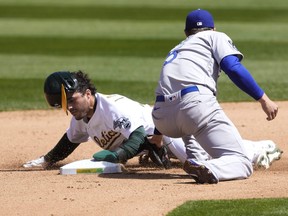 Ramon Laureano of the Oakland Athletics steals second base ahead of the throw to Corey Seager of the Los Angeles Dodgers in the fourth inning at RingCentral Coliseum on April 07, 2021 in Oakland, California.