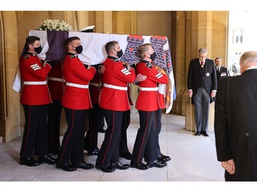 WINDSOR, ENGLAND - APRIL 17: The bearer Party found by The Queen's Company, 1st Battalion Grenadier Guards carry the coffin of HRH Prince Philip, Duke of Edinburgh to the purpose built Land Rover Hearse during the funeral of Prince Philip, Duke of Edinburgh at Windsor Castle on April 17, 2021 in Windsor, England. Prince Philip of Greece and Denmark was born 10 June 1921, in Greece. He served in the British Royal Navy and fought in WWII. He married the then Princess Elizabeth on 20 November 1947 and was created Duke of Edinburgh, Earl of Merioneth, and Baron Greenwich by King VI. He served as Prince Consort to Queen Elizabeth II until his death on April 9 2021, months short of his 100th birthday. His funeral takes place today at Windsor Castle with only 30 guests invited due to Coronavirus pandemic restrictions.