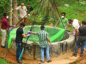 Officials inspect a well and catch bats on May 21, 2018 as they try to stop the spread of the deadly Nipah virus in the Indian state of Kerala.