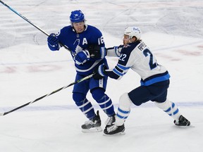 Toronto Maple Leafs forward Mitchell Marner tries to avoid a check from Winnipeg Jets forward Mason Appleton on Thursday night.