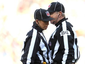 NFL down judge Sarah Thomas (left) confers with referee Mark Steinkerchner during a game last season.