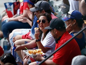 Baseball fans in Arlington, Texas, watch a game between the Blue Jays and the Rangers.