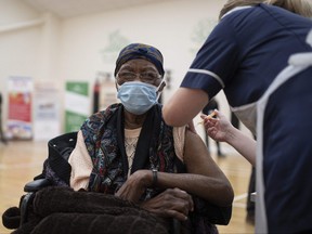 A health worker administers a dose of the AstraZeneca/Oxford COVID-19 vaccine to a patient at a vaccination centre set up at the Karimia Institute Islamic centre and Mosque in Nottingham, central England on April 6, 2021.