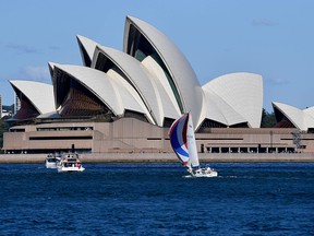 A boat sails in front of the Opera House on a sunny day in Sydney on April 10, 2021.