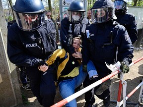 Policemen remove a protester during a demonstration against restrictions implemented by the government in order to limit the spread the coronavirus, in Berlin on April 21, 2021.