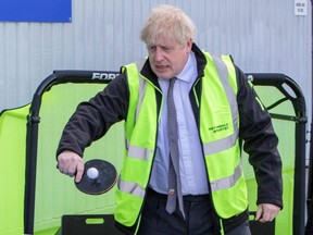 Britain's Prime Minister Boris Johnson plays table tennis during his visit to Net World Sports as he campaigns on behalf of Conservative Party candidate Jeremy Kent in Wrexham, Wales, on Monday, April 26, 2021.