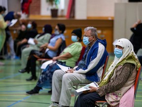 People wait their turn as nurses from Humber River Hospital's mobile vaccine clinic administer the Moderna COVID-19 vaccine at Toronto and Region Islamic Congregation Centre as part of the COVID-19 vaccination campaign, in Toronto, April 1, 2021.