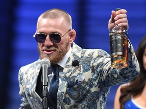 Conor McGregor speaks to the media while holding up his brand of whiskey on August 26, 2017 at T-Mobile Arena in Las Vegas.