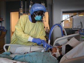 Registered nurse Jane Abas tends to a COVID-19 variant patient who is intubated and on a ventilator in the intensive care unit at the Humber River Hospital in Toronto, Tuesday, April 13, 2021.