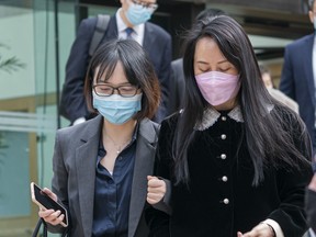 Meng Wanzhou, chief financial officer of Huawei, leaves B.C. Supreme Court with an acquaintance during a lunch break at her extradition hearing, in Vancouver, B.C., Thursday, April 1, 2021.