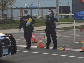 Durham Regional Police lay markers at the scene at Harwood Ave. and Kingston Rd. in Ajax after more than 40 shots were fired on Wednesday, April 28, 2021.