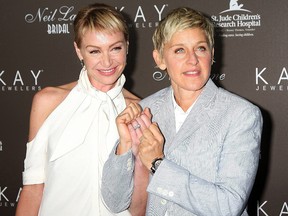 Portia DeRossi  and Ellen DeGeneres show off their wedding rings as they arrive at the Neil Lane Bridal Collection Debut at Drai's at The W Hollywood Rooftop Los Angeles.